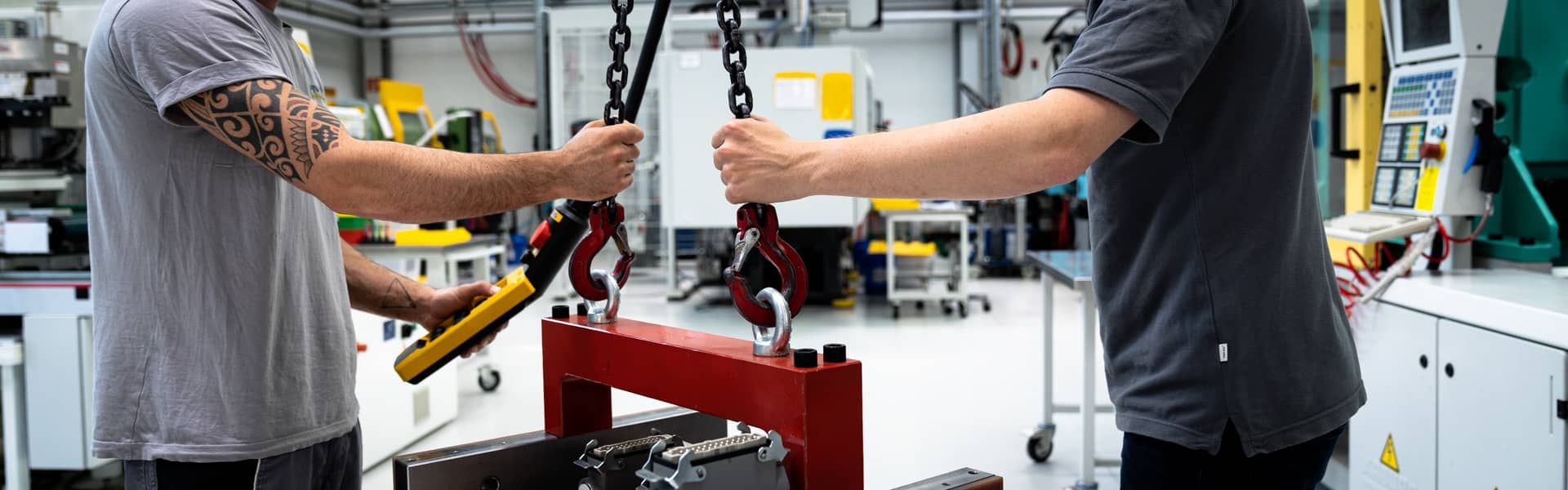 2 Mitarbeiter hängen das neue Werkzeug an den Kranen